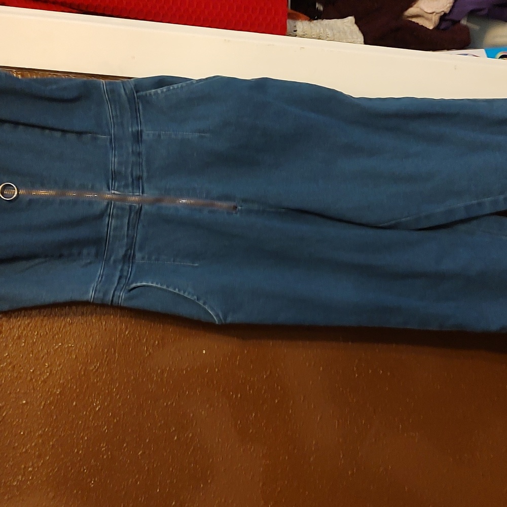 A lady's blue jean jumper sleeveless zipper in front long pants jean jumper